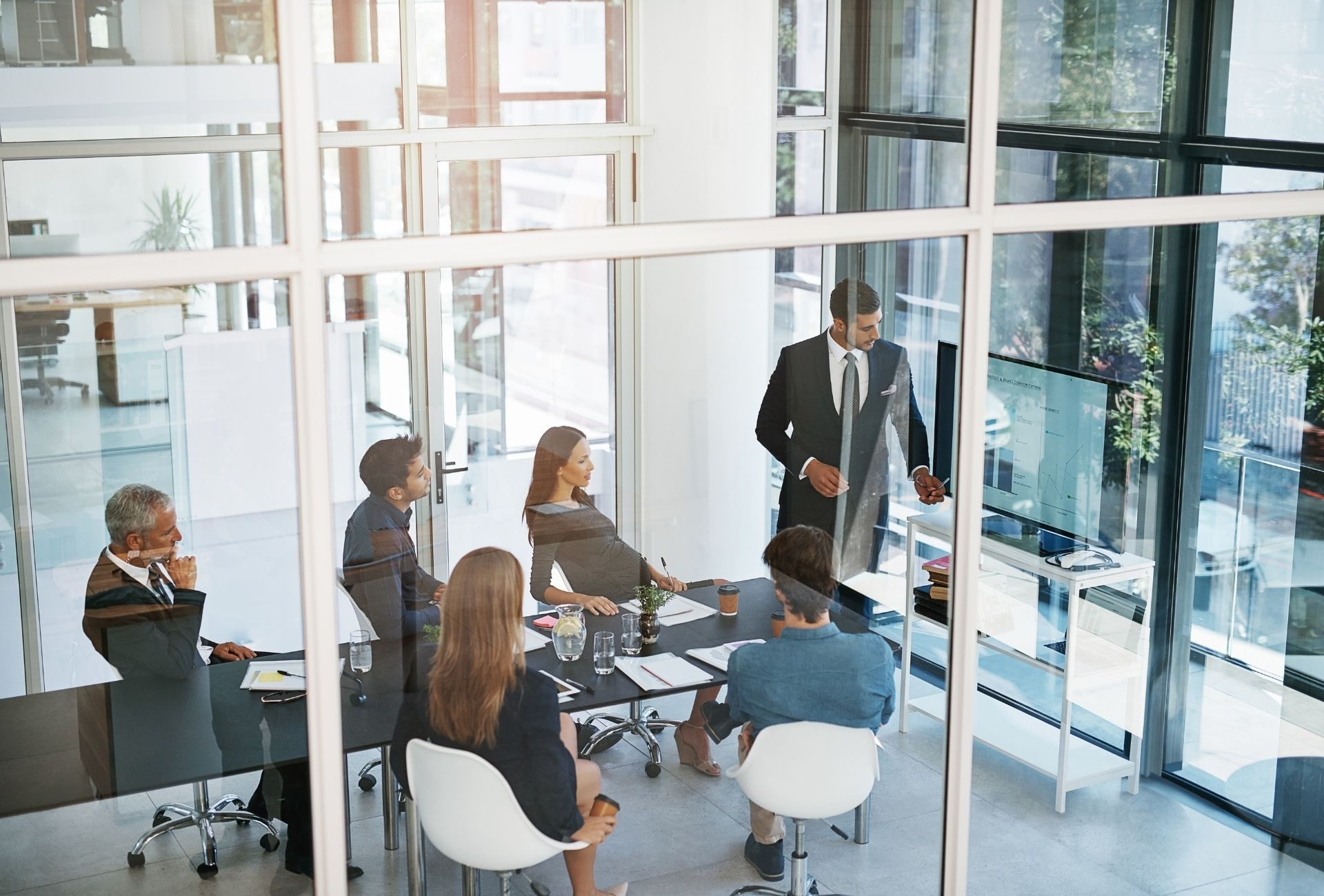 A hiring team meeting in a bright glass-walled office